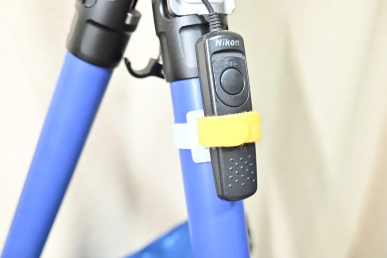 マジックテープを巻いたレリーズを三脚の脚につけたところ